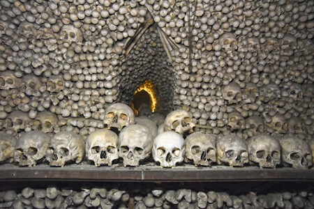 NOS OSSOS QUE AQUI ESTAMOS, PELOS VOSSOS ESPERAMOS. UNSERE KNOCHEN HIER WARTEN AUF DIE EUREN.Spruch in der Capela dos Ossos (Knochenkapelle) im portugiesischen Évora