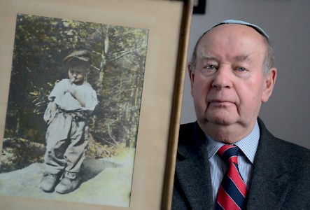 »Ich war ein kleiner Partisan« – Tadeusz Jakubowicz mit einem Foto, das kurz nach Ende des Zweiten Weltkriegs aufgenommen wurde und ihn als Sechs­jährigen zeigt.