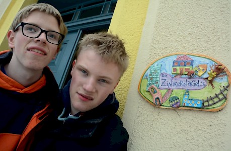 Zwei besondere Kinder vor einem besonderen Türschild: Cornelius und Jacob Zinkernagel.