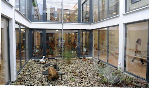 Große Fensterflächen lassen viel Licht in die Räume der »Wohninsel Demenz«. Rund um das Atrium verläuft der sogenannte Endlosflur, der den Bewohnern auch bei Regenwetter ausreichende Bewegung ermöglicht.