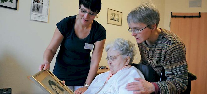 Seelsorgerin Anne-Kristin Kupke (rechts) und Pflegerin Sabina Günnel besuchen eine Bewohnerin des Leipziger Alten- und Pflegeheimes »Johann Heinrich Wichern«. Beim gemeinsamen Betrachten von alten Fotos lassen sich Erinnerungen teilen und manchmal auch leichter tragen.