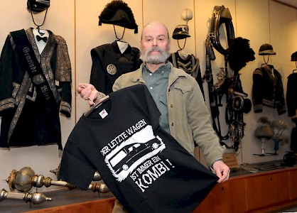 »Der letzte Wagen ist immer ein Kombi« – Kurator Wittigo Keller mit einem modernen T-Shirt vor historischen Bestatteruniformen. 